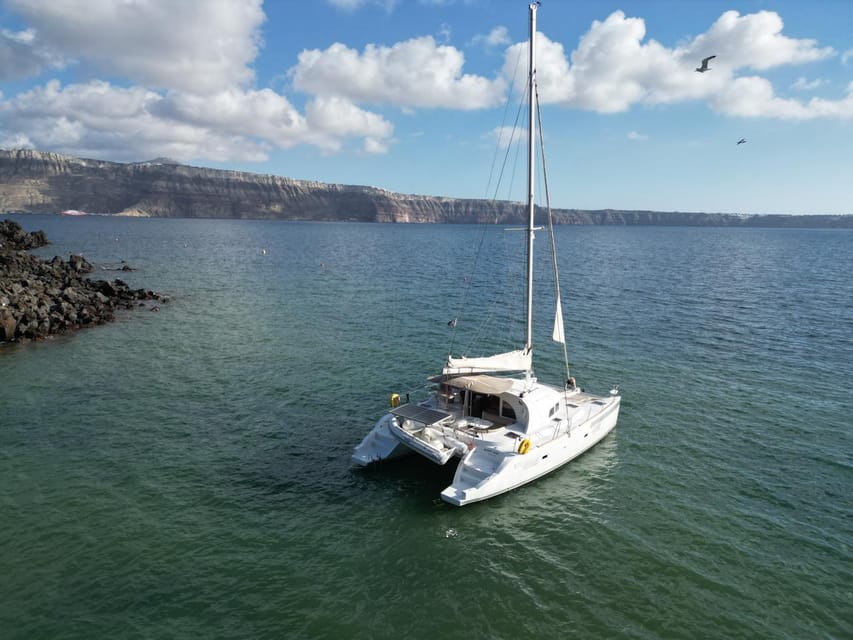 Santorini: Catamaran Cruise with Greek BBQ and Drinks - Red Beach and the southern volcanic coast
