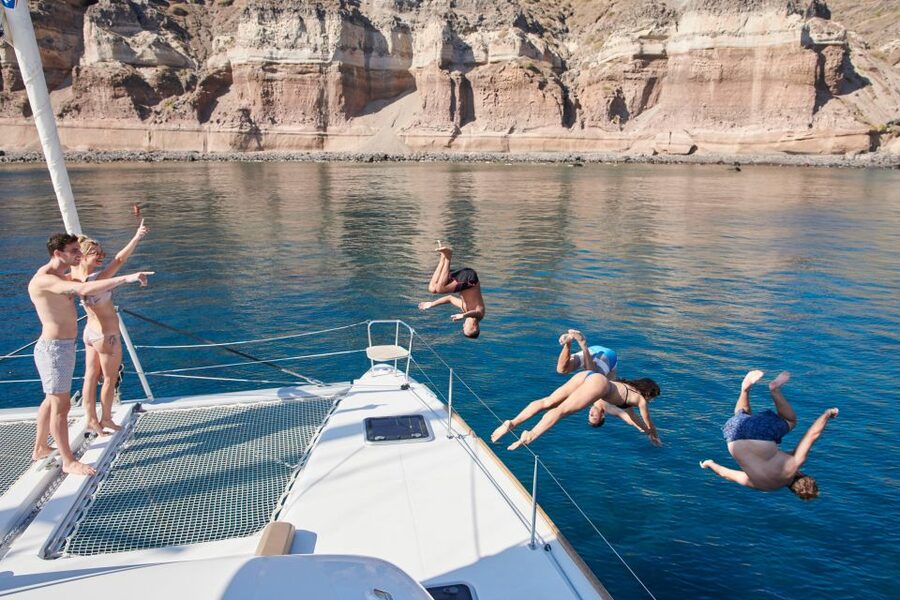 Santorini Gold Catamaran Cruise with Snorkel, BBQ & Open Bar - Leaving Vlychada Marina with wine in hand